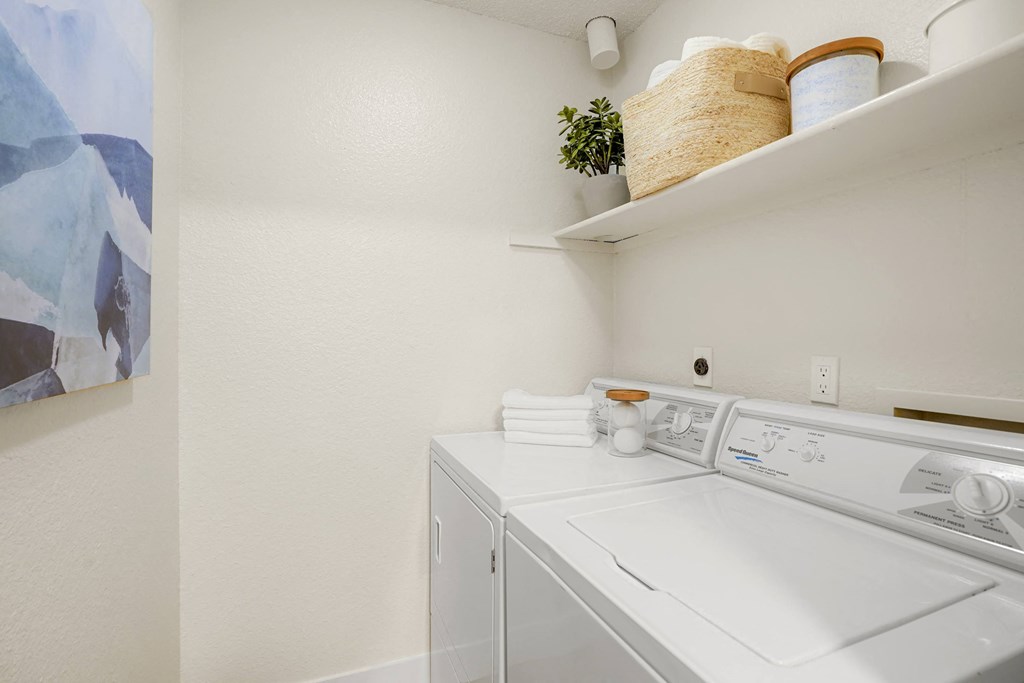 a white washer and dryer in a white laundry room
