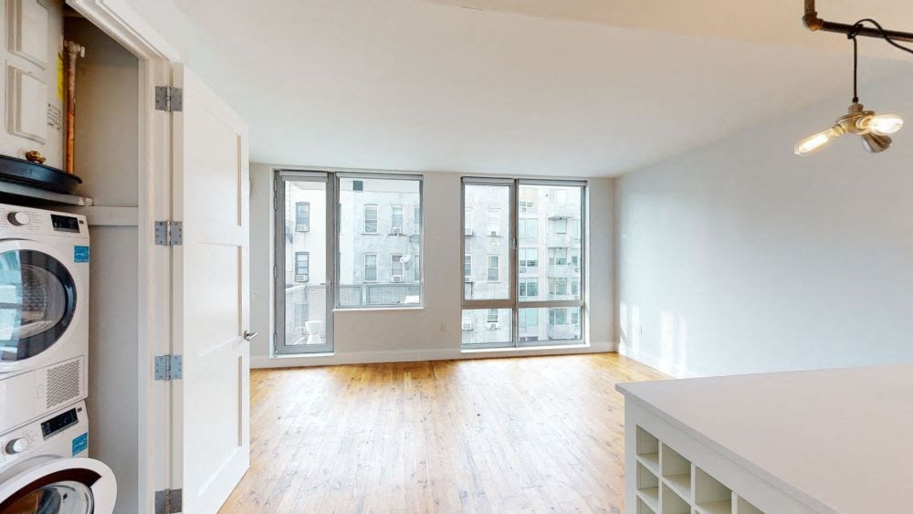 A modern kitchen with a washing machine and a view of the city.