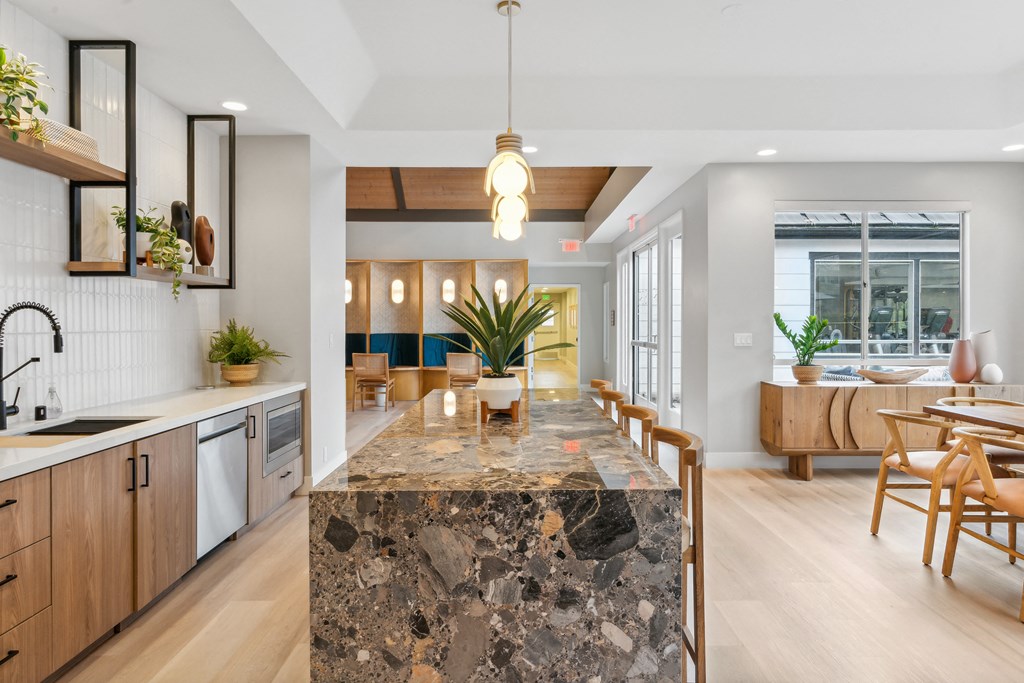 the kitchen and dining area of a modern home with a large granite counter top