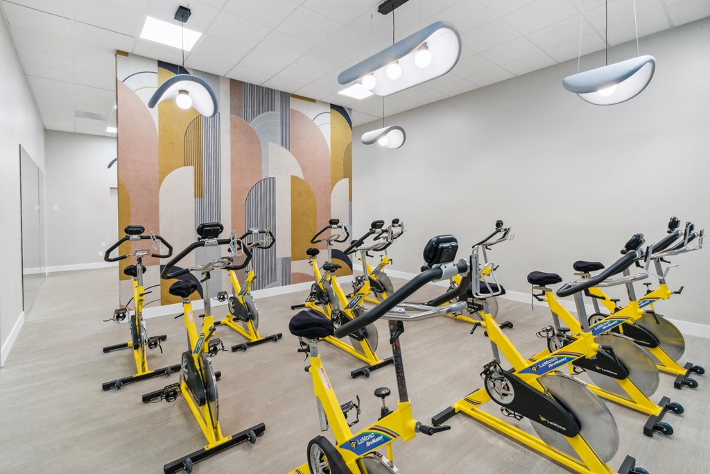a gym filled with yellow exercise bikes