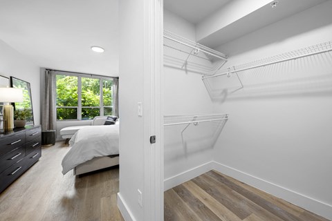 a bedroom with a bed and a closet with white walls