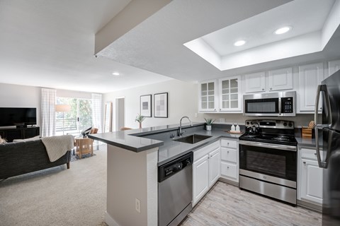 A modern kitchen with stainless steel appliances and white cabinets.