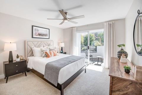 A bedroom with a large bed and a ceiling fan.