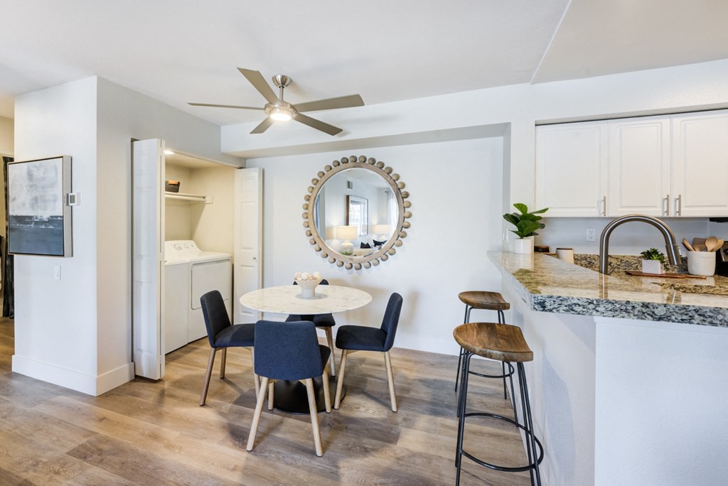 a dining area with a round table and four stools