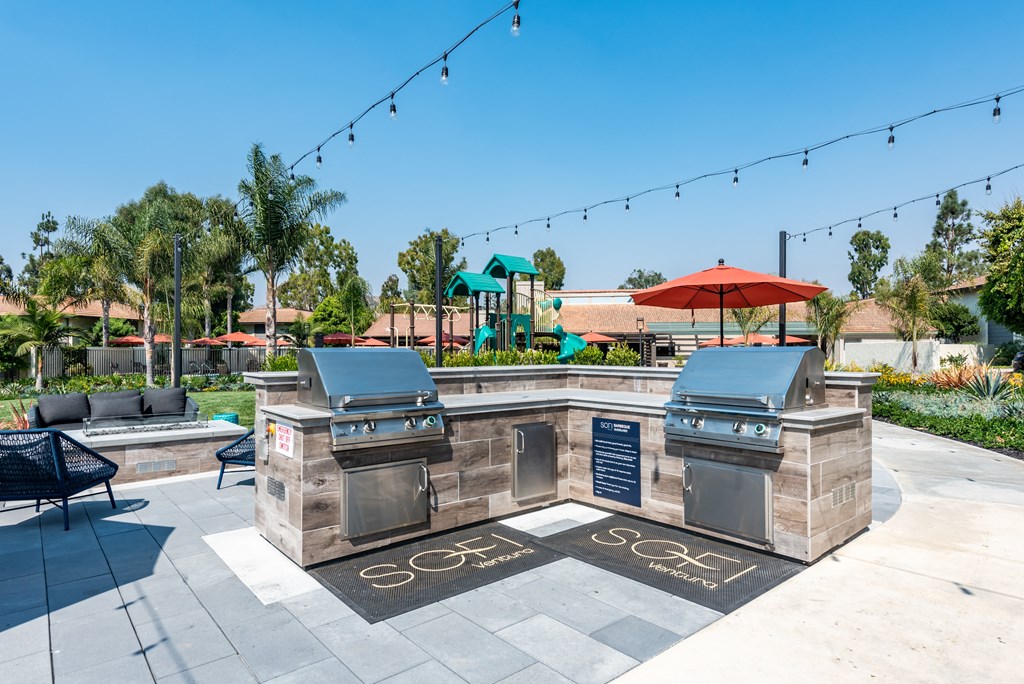 two grilling stations with umbrellas in the clubhouse at villas at houston leve