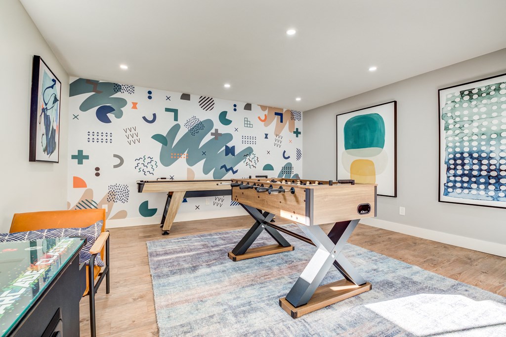a games room with a foosball table and ping pong table