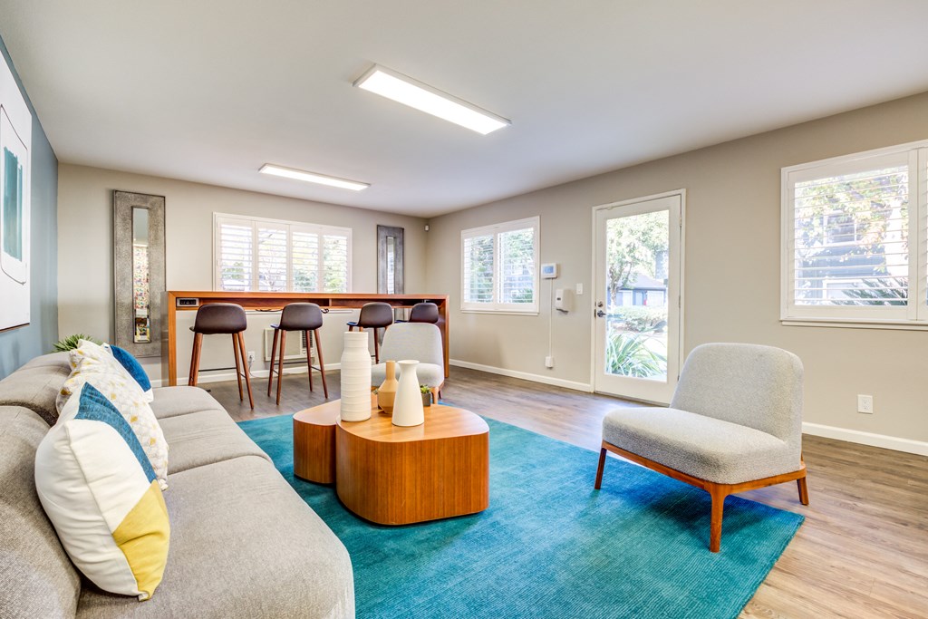 a living room with a couch chair and coffee table on a blue rug
