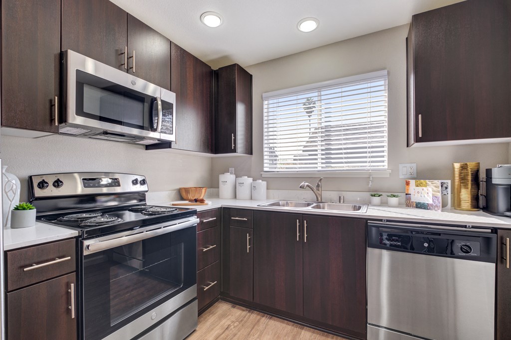 a kitchen with dark wood cabinets and stainless steel appliances