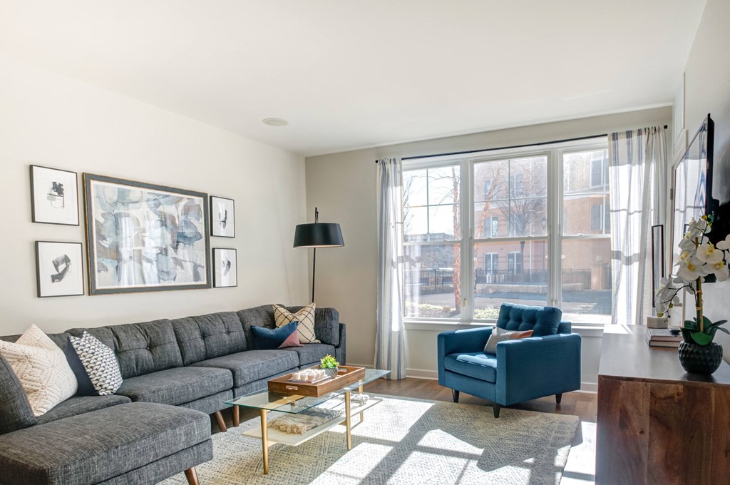 a living room with couches and chairs and a large window