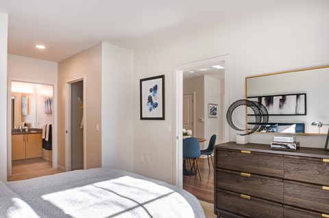 a bedroom with a bed and a dresser and a living room