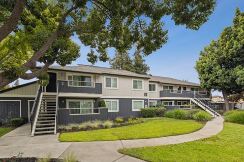 A modern two-story house with a grey exterior and a green lawn.