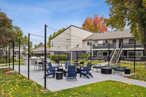 A patio with chairs and tables is surrounded by a black fence.