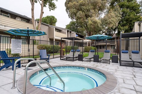 A small pool surrounded by chairs and umbrellas.