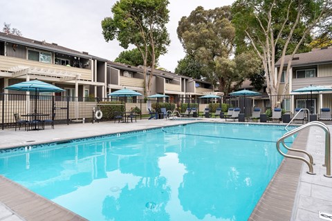 A swimming pool in front of apartment buildings.