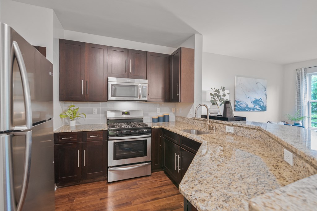 an updated kitchen with granite counter tops and stainless steel appliances