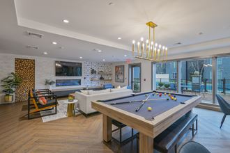 a pool table in a living room with a couch and a tv
