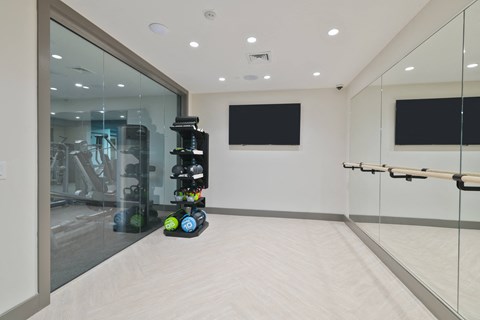 a fitness room with a treadmill and a tv on the wall