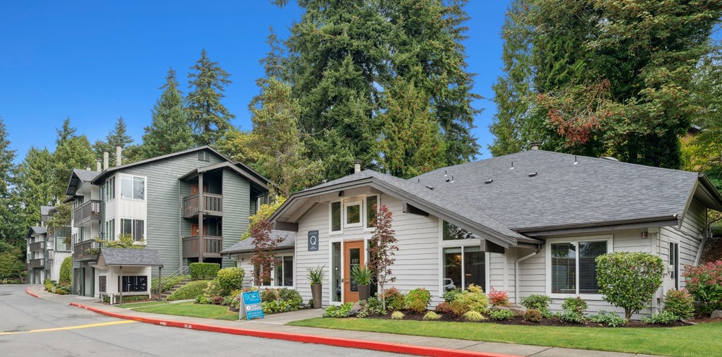 A row of houses with trees in the background.