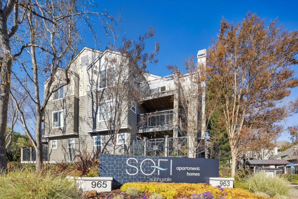 A modern apartment complex with the sign "SOFI Apartments" in front.