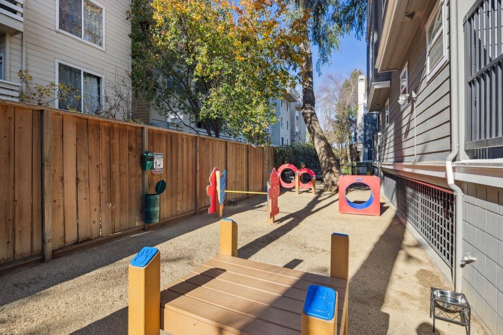 A playground with a wooden fence and a slide.