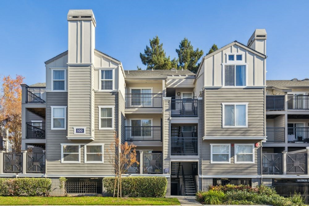 Apartment buildings with balconies and a clear blue sky.