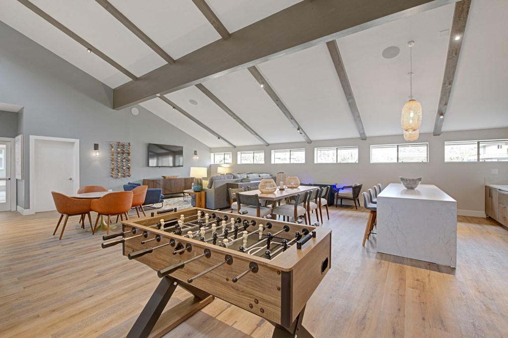 a large clubhouse with foosball table, dining area, lounge area, and kitchen