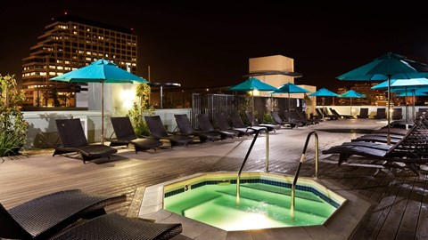 A pool area with a hot tub and lounge chairs.