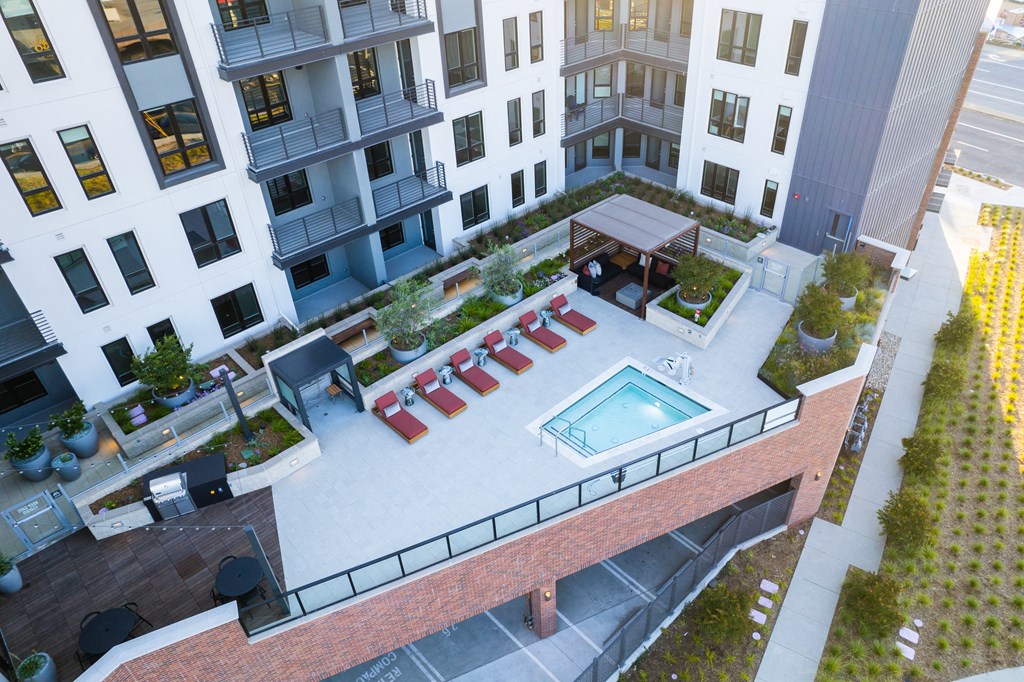 an overhead view of an apartment building with a pool and lounge chairs
