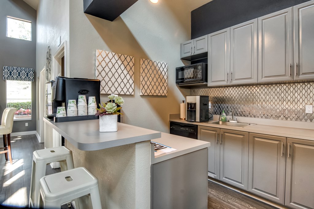 a kitchen with white cabinets and a counter with stools