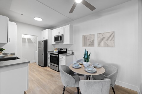 A modern kitchen with a dining table set for two.