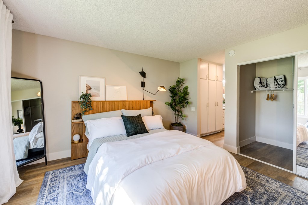 a bedroom with a bed and a mirror and a closet