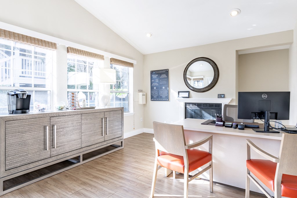 a room with a desk and chairs and a television