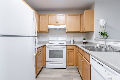 a kitchen with white appliances and wooden cabinets