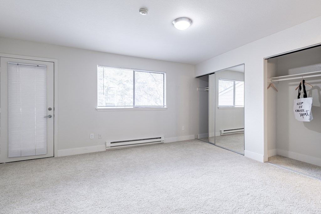 an empty bedroom with a closet and a mirror