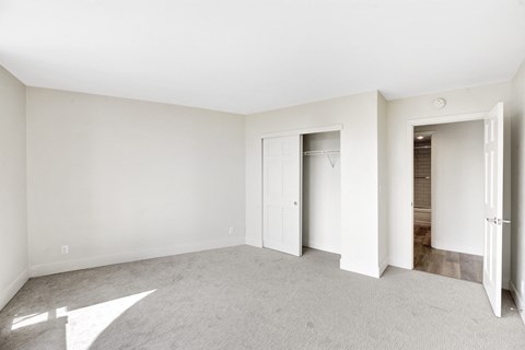 an empty living room with white walls and a closet