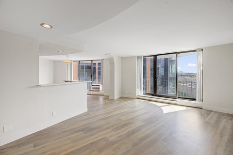 an empty living room with a large window and a balcony