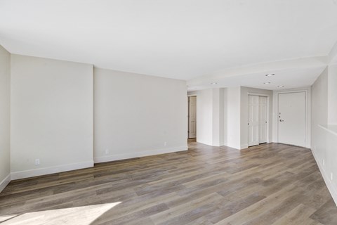 an empty living room with white walls and wood flooring
