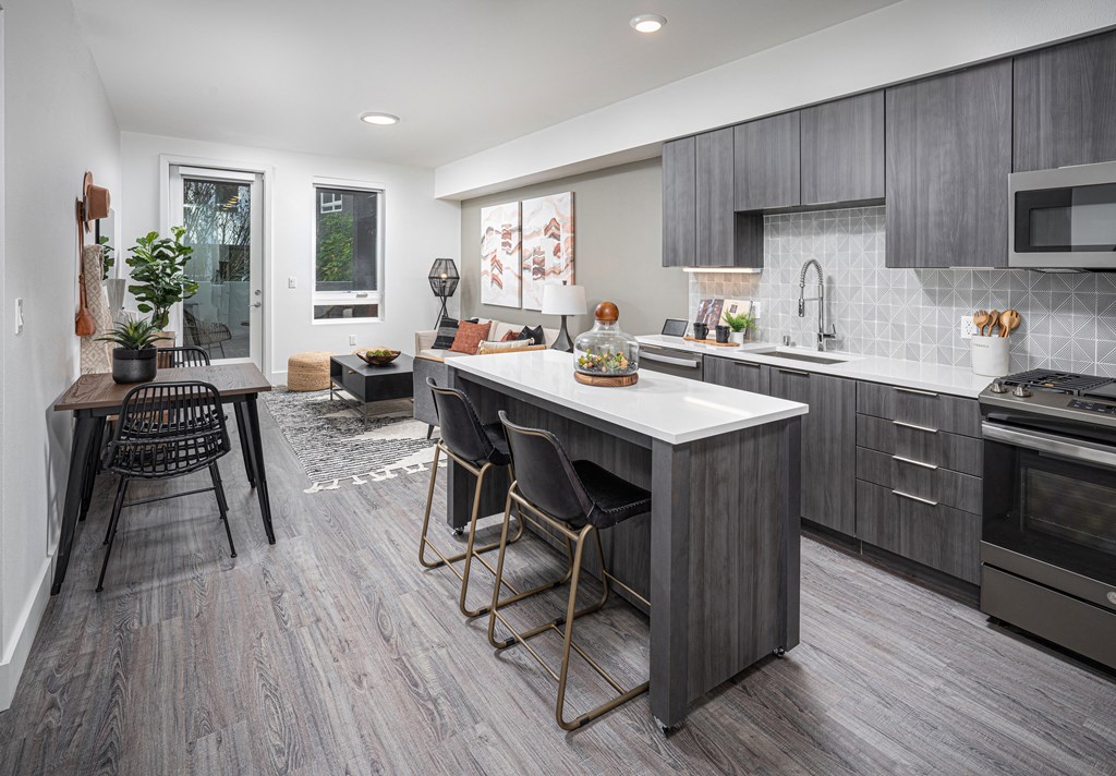 a kitchen with a large island and a table with chairs