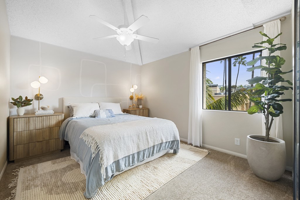 a bedroom with a bed and a large window