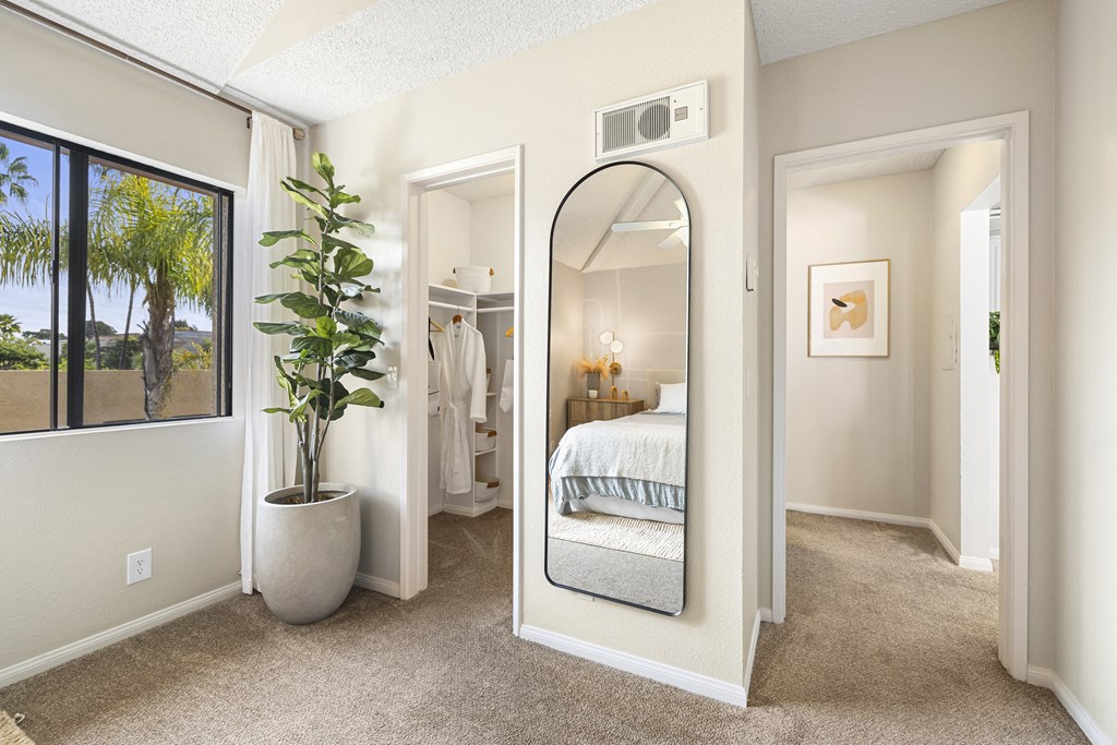 a bedroom with a large mirror and a closet with a bed