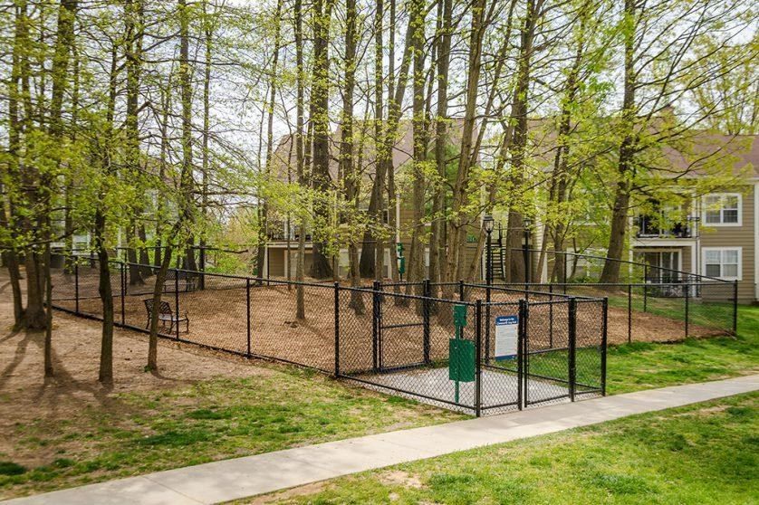 a fenced in dog park in front of a house