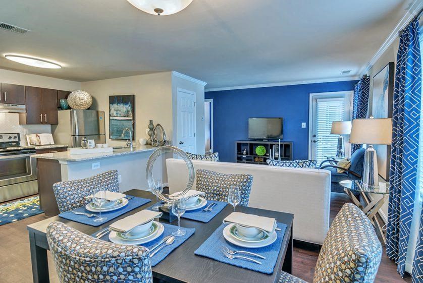 a living room and dining room with a table and chairs