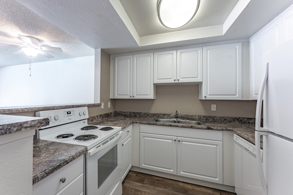a kitchen with white cabinets and a white stove top oven