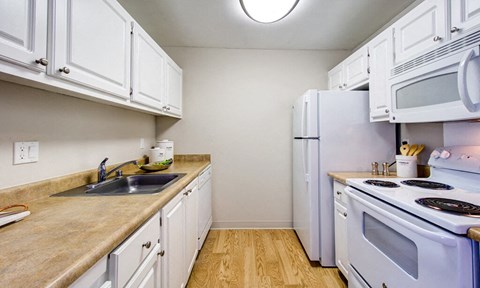 a kitchen with white appliances and white cabinets