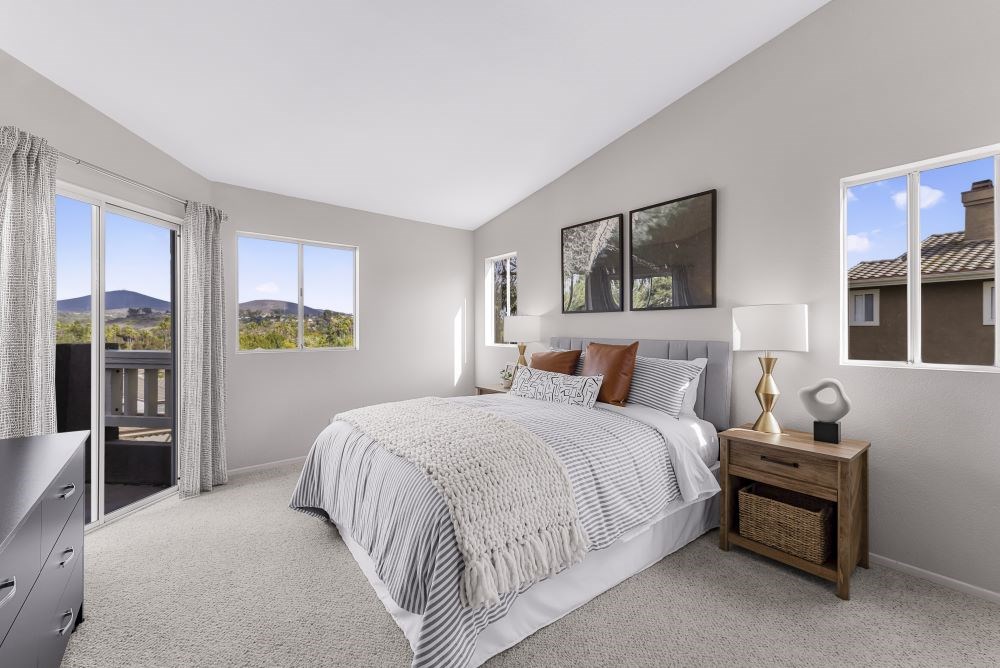 A bedroom with a large bed and a view of the mountains outside the window.