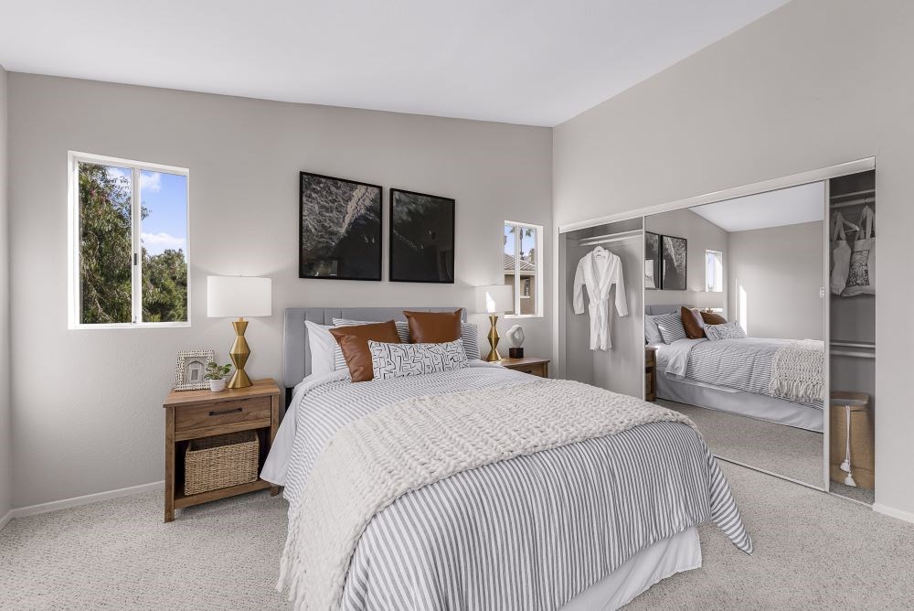 A bedroom with a large bed and a mirror on the wall.
