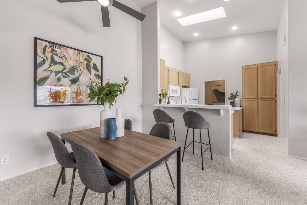 A dining area with a wooden table and grey chairs.