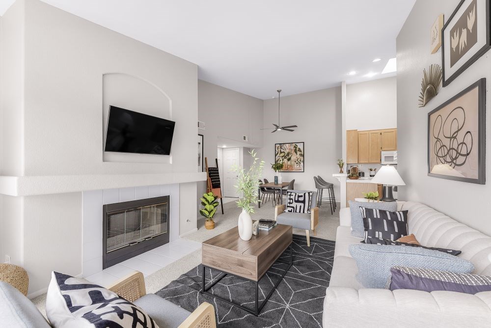 A modern living room with a fireplace and a flat screen TV mounted on the wall.