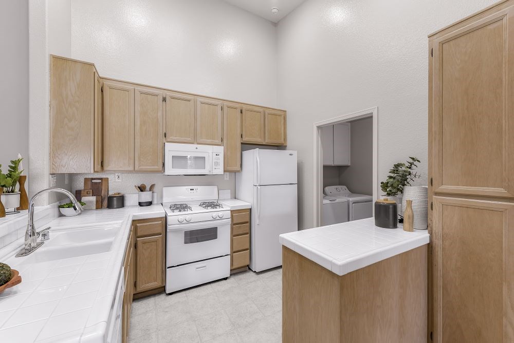 A kitchen with white appliances and wooden cabinets.