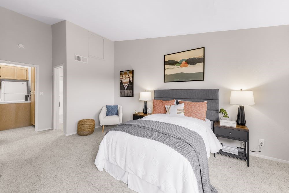 A bedroom with a large bed and a painting on the wall.